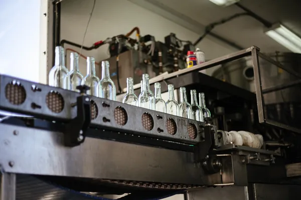 Empty wine bottles advancing along automated conveyor bottling line
