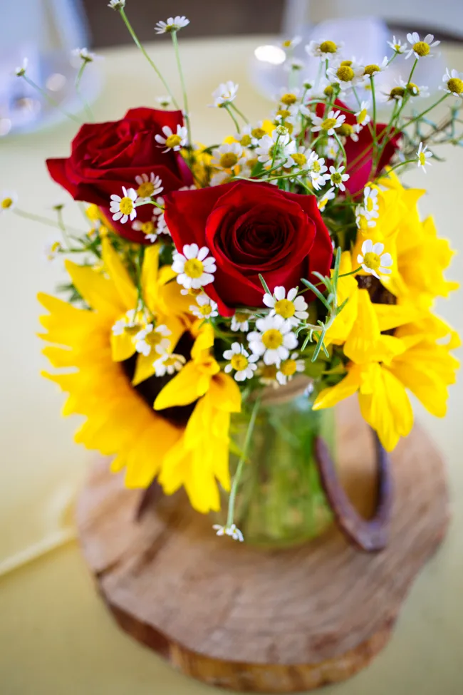 Red roses, white daisies, and yellow flowers in celebration bouquet