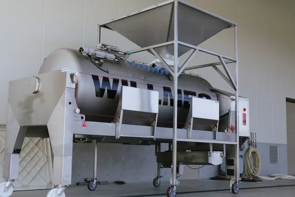 Industrial grape crusher and de-stemmer equipment at production facility