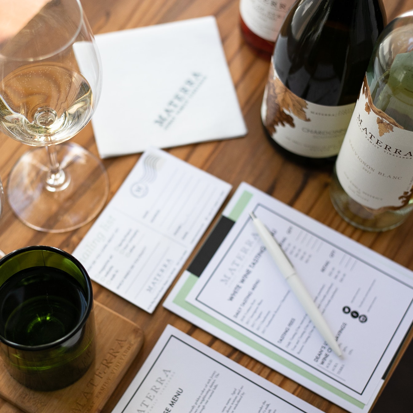 A photo of a typical wine tasting set up including glasses, bottles and order forms.