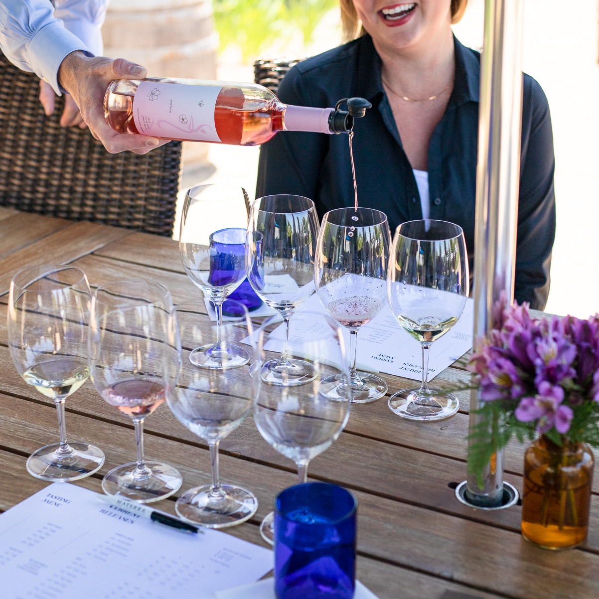 A bottle of rosé wine laid flat on a bed of pink cherry blossom petals